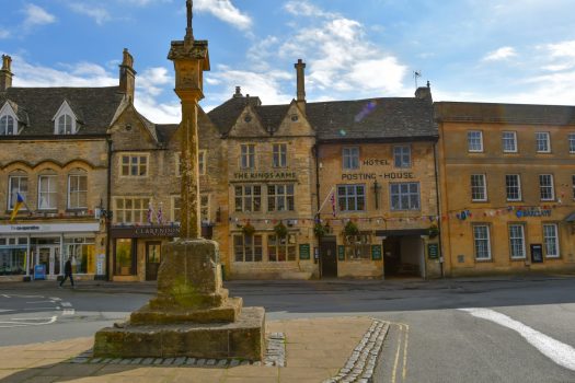 The War Memorial in front of shops & pub in Stow on the Wold in Summer
