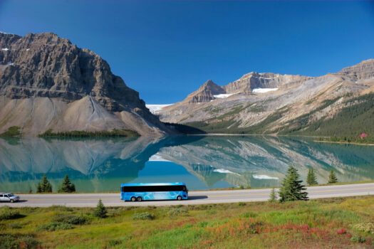 Tour bus driving by Bow Lake on the Icefields Parkway in Banff National Park Alberta