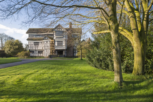 A view through the trees to Little Moreton Hall, a Tudor Manor House