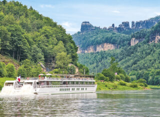 Boat cruising along a river through hills
