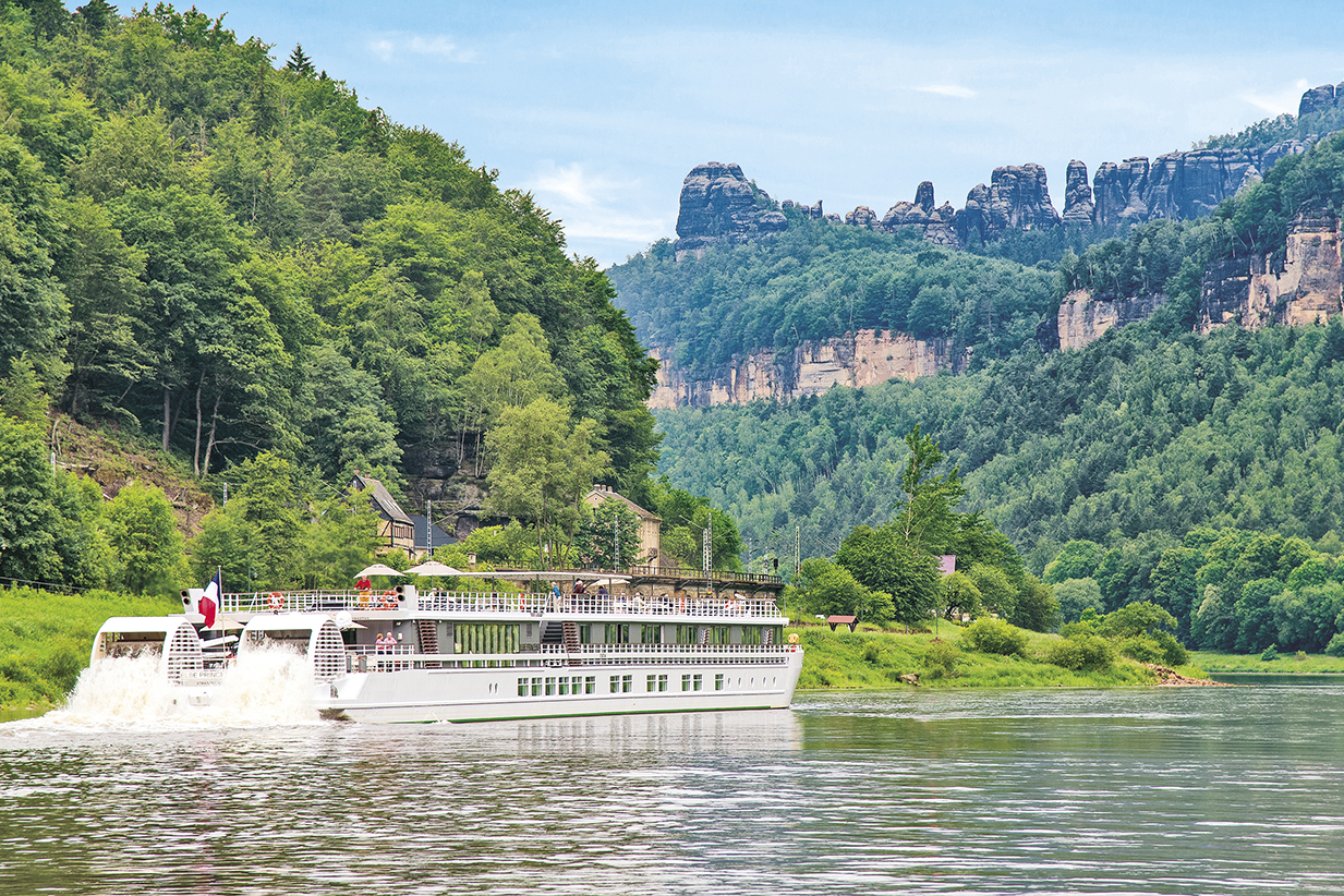 Boat cruising along a river through hills