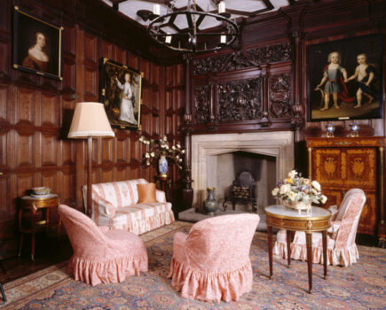 The Queen's Room at Sizergh Castle showing oak panelling, stone Tudor fireplace, carved oak overmantel & armchair